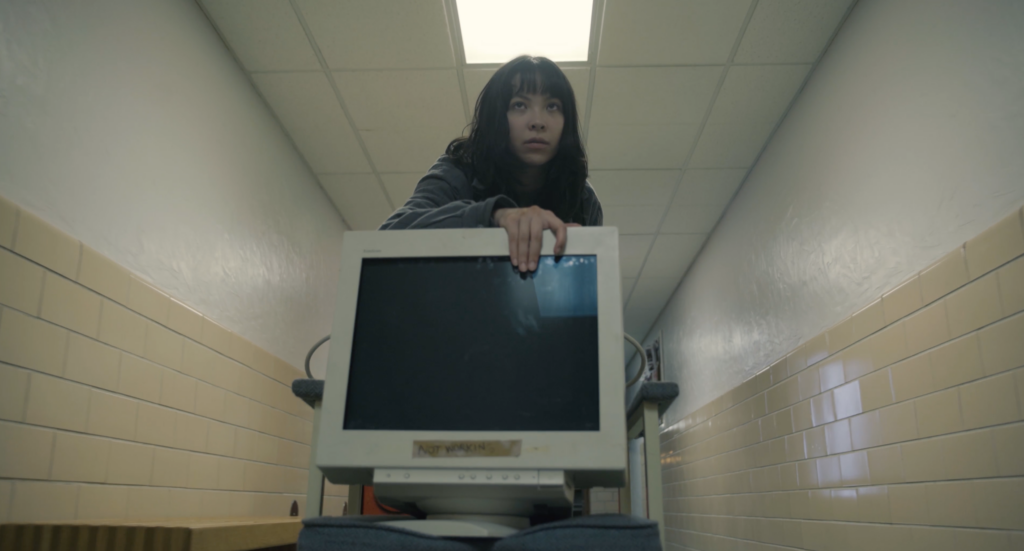Person moving toward camera with computer monitor.